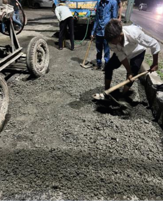 Workers repairing potholes on road